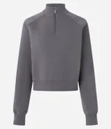 Buzo de algodón con felpa, de corte estructurado y diseño cropped. Presenta cuello alto con medio cierre frontal, mangas largas con puños elásticos y ruedo con elástico ancho.