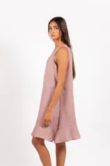 Vestido corto de lino con estampado de cuadros vichy en tonos rosado y blanco, sin mangas, con escote redondo y volado caracol en el ruedo.