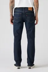Jean de corte slim fit, color azul oscuro con efecto lavado sutil. Presenta cierre de botones y cinco bolsillos clásicos.
