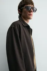 Sobrecamisa regular fit color gris oscuro, confeccionada en tejido con viscosa. Presenta cuello solapa, manga larga con puño abotonado, bolsillos de vivo en la cadera y cierre frontal con cremallera.