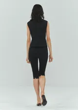 Pantalon capri entallado de tiro medio, con costuras decorativas y cierre de cremallera invisible en la parte posterior.