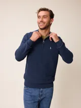 Sweater de punto color negro, con cuello alto y cierre frontal parcial tipo medio cierre. Presenta textura en el tejido y logo bordado en el pecho.