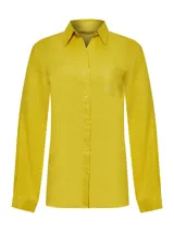 Blusa de manga larga confeccionada en lino orgánico, con cuello camisero, cierre frontal de botones y bolsillo en el pecho.