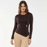 Camiseta de manga larga color marrón, confeccionada en tejido elástico, con cuello redondo y detalle de fruncido lateral con adorno metálico dorado. Presenta un corte asimétrico en el ruedo.