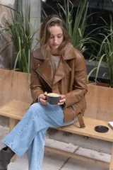 Chaqueta negra de eco-cuero, corte recto y oversize, con solapas amplias, múltiples bolsillos y cierres en las mangas.