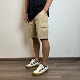 Bermuda cargo de gabardina color beige, con bolsillos laterales con solapa y bolsillos frontales tipo ojal.