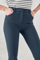 Pantalón de vestir azul marino, de corte skinny y tiro medio, con bolsillos laterales y cierre invisible en el lateral.