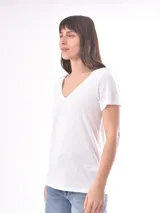 Remera blanca de manga corta con escote en V, de tejido ligero y ligeramente traslúcido.