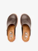 Zueco marrón de cuero con tacón de aguja, punta cerrada y apliques metálicos plateados.