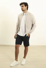 Bermuda verde oscuro de lino y algodón, corte relaxed fit, con cintura elástica ajustable con cordón, bolsillos frontales y traseros.