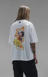 Remera blanca de corte oversize con estampa frontal de Goku sobre la nube voladora rodeado de las esferas del dragón.