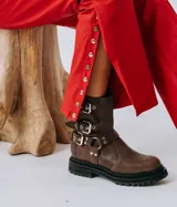 Botas de caña media color negro, confeccionadas en cuero natural, con suela track y plataforma alta. Cuentan con múltiples correas con hebillas metálicas plateadas y tachas decorativas.