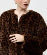 Saco de pelo sintético con estampado animal print, de corte recto y largo estándar. Presenta cuello redondo, manga larga y cierre frontal oculto.