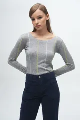 Remera de manga larga en color gris melange, con cuello redondo y costuras decorativas verticales en contraste de color verde lima y blanco.