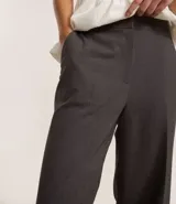 Pantalón de corte recto y estilo sastre, color azul marino, con bolsillos laterales tipo cuchillo y cierre frontal.