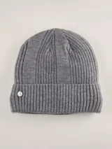 Gorro de lana gris con diseño acanalado y parche metálico con logo en el lateral.