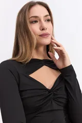 Top de manga larga confeccionado en licra satinada, con diseño ajustado al cuerpo. Presenta un escote con recortes estratégicos y detalles drapeados en el frente que aportan un toque sofisticado.