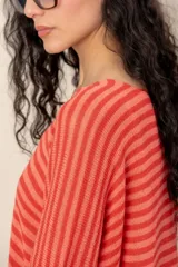 Sweater de tejido de punto a rayas horizontales en tonos beige y blanco, con escote en V y mangas cortas holgadas.