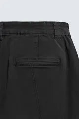 Pantalón cargo de corte relajado confeccionado en tejido de algodón con elasticidad. Presenta bolsillos laterales tipo cargo con solapa en las perneras, bolsillos frontales y bolsillos traseros de doble vivo. Cierre frontal con cremallera y botón.