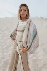 Pantalón de lino a rayas horizontales en tonos naranja, rosa y gris.