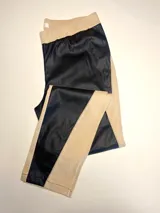 Pantalón combinado tostado, confeccionado con un panel frontal de cuerina elástica en tono camel y un panel posterior de gabardina con spandex en tono tostado. Presenta una cintura elastizada para mayor comodidad y costuras a la vista en contraste.