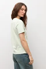 Remera de manga corta color crudo con apliques florales bordados tono sobre tono en el frente.