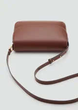 Bolso de hombro tipo bandolera en color marrón, con diseño estructurado de solapa, cierre metálico a presión y costuras decorativas en contraste. Incluye correa larga ajustable.