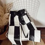 Pantalón de ecocuero con diseño de bloques en blanco y negro.