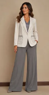 Blazer de lana soft color beige, con cierre frontal de un botón, solapas clásicas y dos bolsillos frontales con detalles de bordado artesanal en relieve. Presenta un diseño estructurado y elegante.