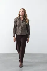 Pantalón de pana color marrón chocolate, de corte recto con bolsillos laterales y cierre frontal.