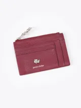 Tarjetero de cuero vacuno color verde oliva, con cierre superior y aplique metálico de flor en el frente.