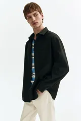 Camisa en sarga suave de mezcla de lyocell y algodón, color verde oscuro, con cuello inglés, bolsillo superior abierto, botones al frente y mangas largas con puños abotonados.