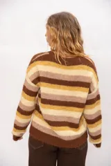 Sweater tejido de calce relajado con diseño de rayas horizontales en tonos marrón, crema y celeste. Presenta cuello redondo, mangas largas y terminaciones acanaladas en puños y cintura.