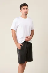 Bermuda deportiva de nylon color negro, de corte suelto, con cintura elástica y cordón de ajuste. Cuenta con detalles de líneas en los costados y bolsillos con cierre.