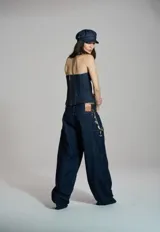 Corset de denim azul oscuro con diseño strapless, escote corazón y costuras pespunteadas que estructuran la prenda.
