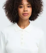 Blusa tipo polo de manga larga confeccionada en algodón, con cuello clásico y cierre frontal de botones. Presenta un diseño de corte regular y acabado suave.