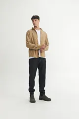 Camisa de corte regular fit confeccionada en algodón con textura tramada en dos tonos. Presenta cuello solapa clásico, cierre frontal con botones personalizados y bolsillo en el pecho.