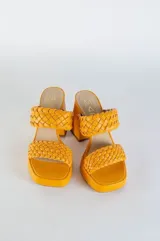 Zuecos color naranja con plataforma y taco cuadrado forrado al tono. Capellada trenzada de cuero.