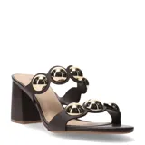 Sandalia tipo mule de tacón ancho, color marrón oscuro, con dos tiras anchas adornadas con grandes apliques metálicos redondos de color dorado brillante.