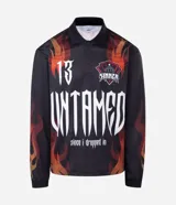 Remera de manga larga con corte boxy, confeccionada en microfibra de poliéster. Presenta un diseño estampado con motivos de llamas en tonos rojos y naranjas, junto con el número 13 en tipografía gótica en la espalda.