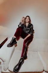 Pantalón de terciopelo color borgoña, corte recto y detalle de encaje negro en los laterales.