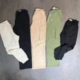 Pantalón cargo verde de nylon, corte holgado con bolsillos laterales y cintura elástica ajustable con cordón.