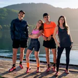 Riñonera deportiva minimalista marca Merrell, color negro, diseñada para trail running. Cuenta con cierre frontal, ajuste elástico y múltiples bolsillos para almacenamiento ligero.
