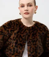 Saco de pelo sintético con estampado animal print, de corte recto y largo estándar. Presenta cuello redondo, manga larga y cierre frontal oculto.