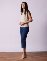 Buzo tejido en hilado fino color beige, con escote en V y sin mangas.