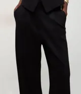 Pantalón de corte recto y estilo sastre, confeccionado en tejido punto roma con caída estructurada. Presenta un diseño minimalista y elegante con cintura definida.