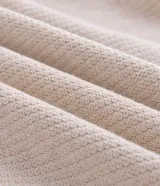 Suéter de punto con textura en zig zag, cuello redondo y manga larga con puños ajustados. Confeccionado en una mezcla de algodón y poliamida.