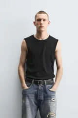 Musculosa blanca de algodón con cuello redondo y sisas amplias.