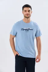 Remera azul marino de manga corta con cuello redondo, confeccionada en mezcla de algodón y poliéster. Presenta un diseño en el frente que combina estampa y bordado con la leyenda "Legacy Brand 1972" en tonos rosado, verde y marrón.