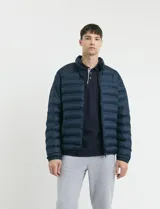 Campera capitoneada de poliéster con cierre frontal al tono y bolsillos laterales con cierre invisible.